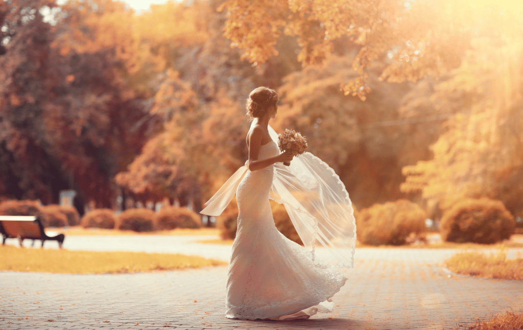 a bride walking in the park in the fall